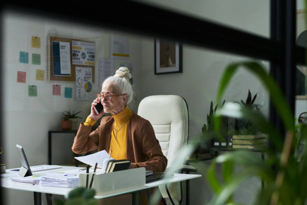 Portrait of Elderly Woman Using Phone in Home Office Setting