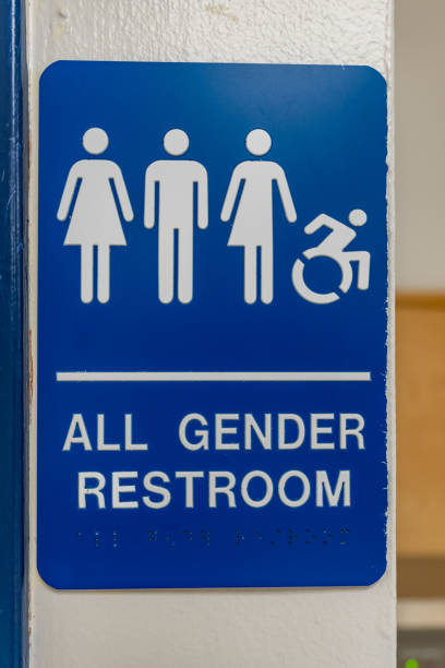 istock Blue and white all gender and accessible restroom sign with Braille code on an interior building wall.. 2172460404