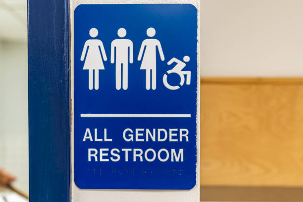 istock Blue and white all gender and accessible restroom sign with Braille code on an interior building wall.. 2172460416