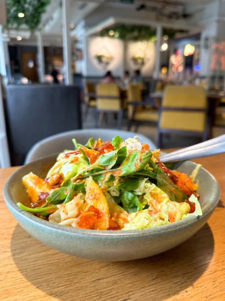 Image of orange citrus salad with dressing / fresh green lettuce and rocket leaves / delightful starter appetizer