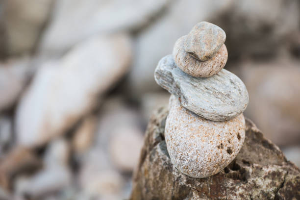 serene beach scene with smooth rocks stacked in a balanced formation. The tranquil atmosphere evokes a sense of zen, harmony, and peace, symbolizing balance and mindfulness in nature