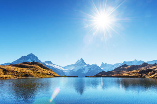 Bachalpsee lake in Swiss Alps mountains. Snowy peaks of Wetterhorn, Mittelhorn and Rosenhorn on background. Grindelwald valley, Switzerland. Landscape photography