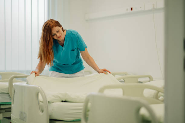 Female nurse arranging bed at the hospital ward.