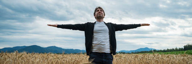 istock peaceful young man practicing mindfulness or meditating as he stands in the middle of golden wheat field 2172481449