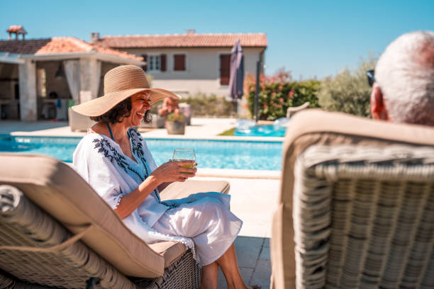istock Senior Hispanic Couple Enjoying Poolside Sun with Refreshing Drinks 2172483191