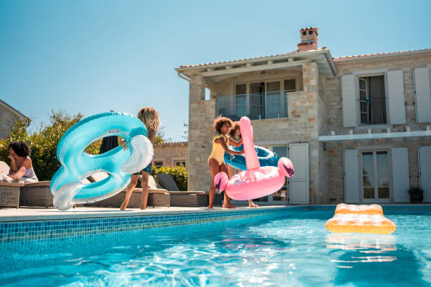 istock Young Mixed Race Boy and Sisters Enjoying Floatie Fun by the Pool 2172483230