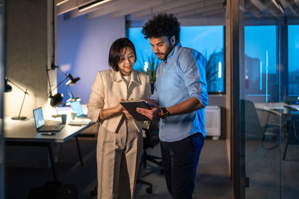 istock Diverse Business Professionals Reviewing Data on Tablet During Late Hours 2172483306
