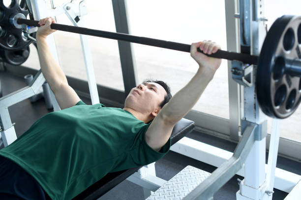 istock Asian young man doing bench press strength training at the gym 2172484152