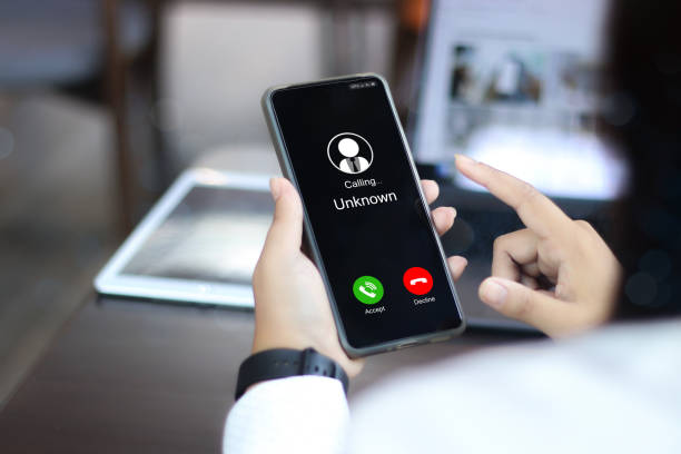 istock Unknown number displayed showing on smart mobile phone. Human use smartphone with incoming call from unknown number, spam, hacker, call center, crime, 2172506263