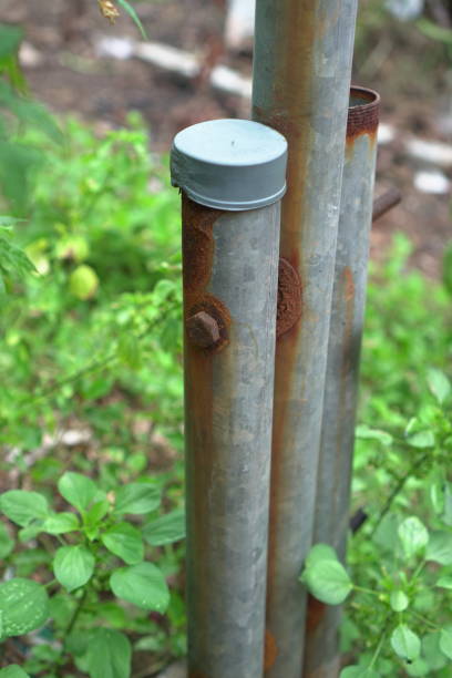 Detailed image of rusty metal fence posts, ideal for creating realistic backgrounds or textures in architectural or industrial designs. Evokes a sense of nostalgia and the passage of time.