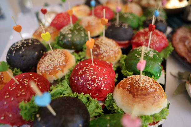 Close-up shot of vegetarian section of colorful vegan burgers on buffet table at gala event without people