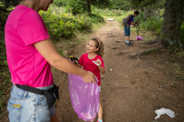 istock Responsible family picking up garbage in pine forest 2172514253