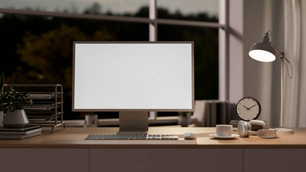 istock A computer with a white screen mockup on a wooden table, illuminated by a table lamp. 2172524291