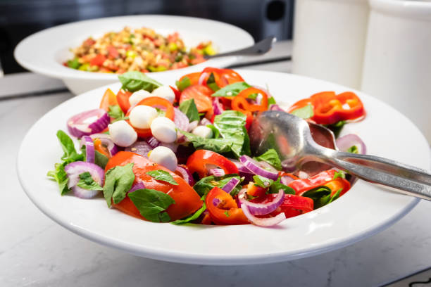 istock Green Salad with Fresh Tomatoes, Bell Peppers, and Onions - Side View 2172527039