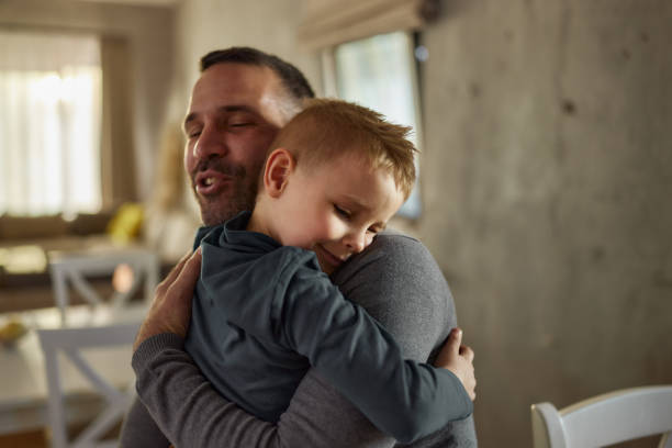 istock Loving son embracing his father in dining room. 2172527678