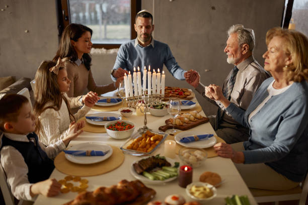 istock Extended family praying before lunch on Hanukkah. 2172528507
