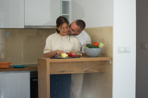 Happy young couple preparing delicious food at home
