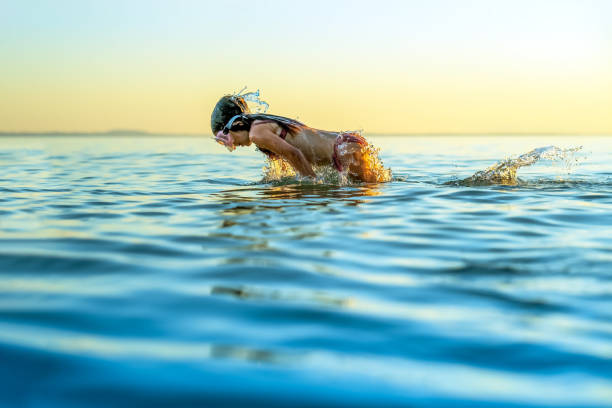 istock jump over water with splashes like fish tail in sunset rays 2172535707