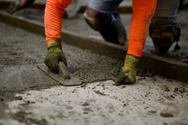 Road crew uses hand trowel to finish concrete