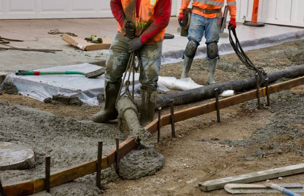 istock Road crew directs the flow of wet concrete 2172537788