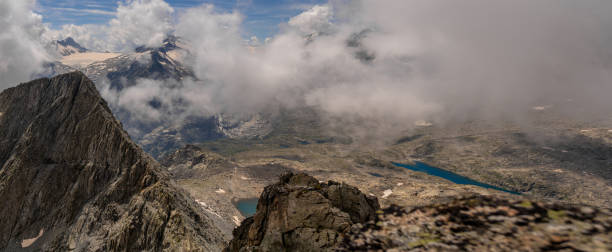 istock Panoramic Alpine View with Clouds and Snow-Capped Peaks 2172538345