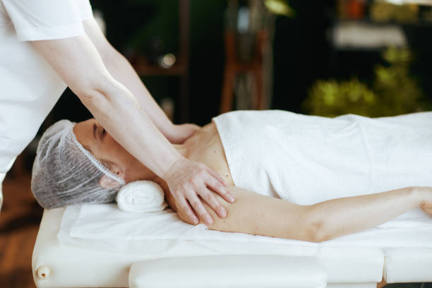 istock massage therapist massaging clients shoulder on massage table 2172544198