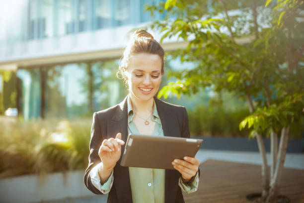 istock happy woman worker near office building using digital tablet 2172544470
