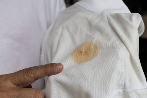 istock Hand holding white t-shirt with brown stain 2172546615