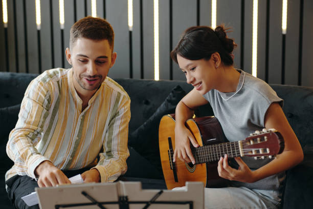 istock Playing Acoustic Guitar Together on Cozy Couch 2172546932