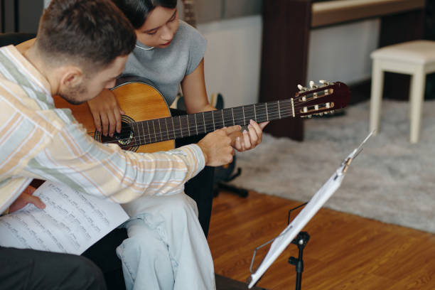 istock Learning Acoustic Guitar with Teacher in Music Studio 2172546939