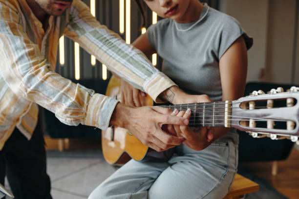 istock Teaching Guitar to Young Woman Using Acoustic Guitar 2172547216