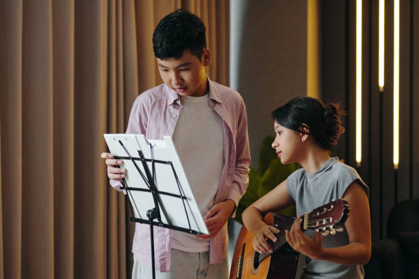 istock Playing Guitar and Reading Sheet Music Together 2172547924