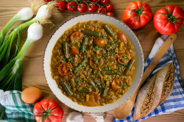 istock Lentil soup with green beans and cherry tomatoes. Top view table with  decoration. 2172550014