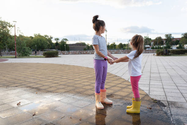 Two sisters holding hands in park