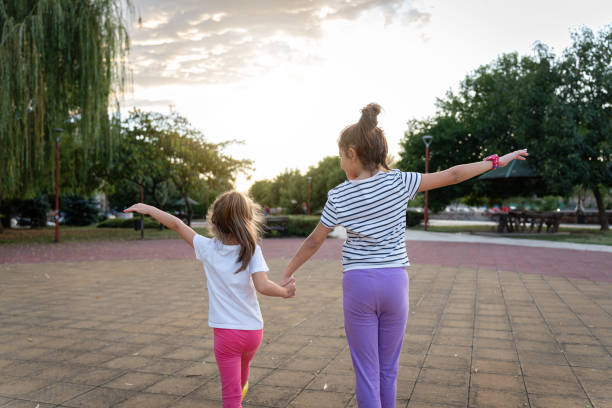 Sibling walking at park rear view