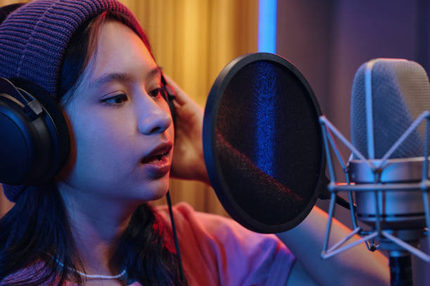 istock Recording Young Woman Singing in Professional Studio 2172552230