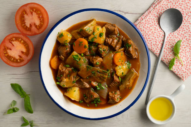 istock Beef stew with potatoes and artichoke. Top view table with  decoration. 2172552737