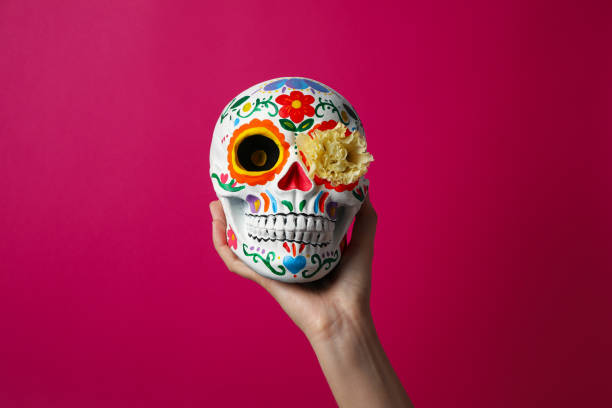 istock Mexican skull with flower in hand on pink background 2172553793
