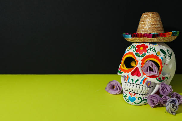 Mexican skull, flowers and sombrero on green background, space for text