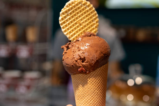 istock hand holding chocolate ice cream cone close up isolated 2172557030