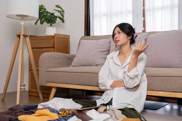 istock Young Woman Feeling Stressed While Packing Her Suitcase at Home, Preparing for a Trip, Surrounded by Clothes and Travel Essentials 2172558775