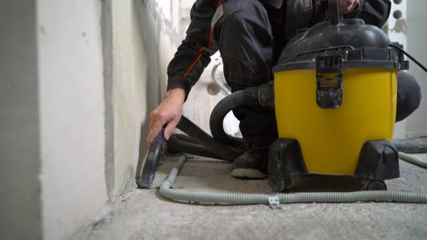 istock A worker vacuums a concrete floor. Worker washes the floor with a vacuum cleaner from industrial concrete dust and cement mud during home renovation 2172558889
