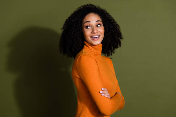istock Photo of shiny attractive lady dressed orage pullover arms crossed loking back empty space isolated green color background 2172559376