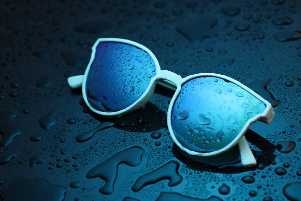 Sunglasses in blue light with water drop
