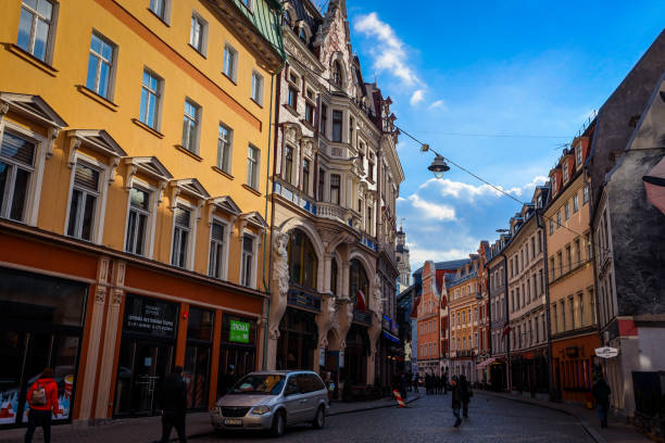 Riga, Latvia - December 19, 2023: Wander through the lively streets of Riga, where colorful buildings line the narrow roads. Admire the intricate architecture and enjoy the atmosphere as people stroll by.