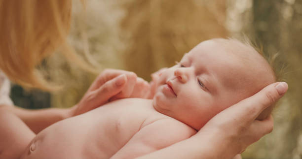 istock Newborn's head in mother's hands. 2172567523