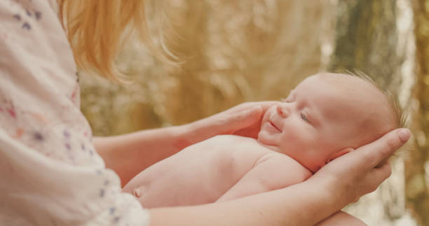 istock Newborn's head in mother's hands. 2172567539