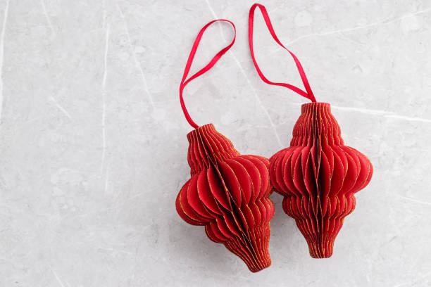 istock Two Red Christmas paper bauble as shape Lantern on marble grey table, Scandinavian Christmas honeycomb ornaments. New year paper decor, modern xmas decoration, minimal winter holiday card 2172570145