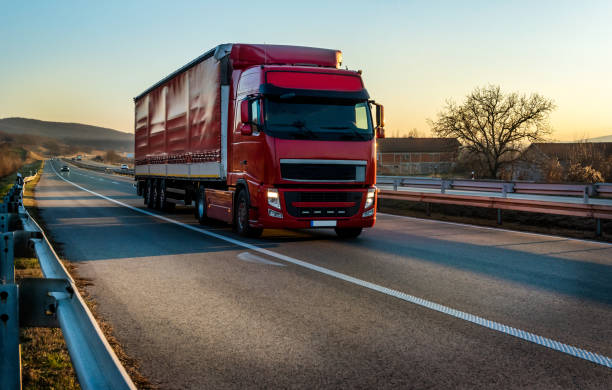 istock Big Red semi trailer truck on a highway 2172572034