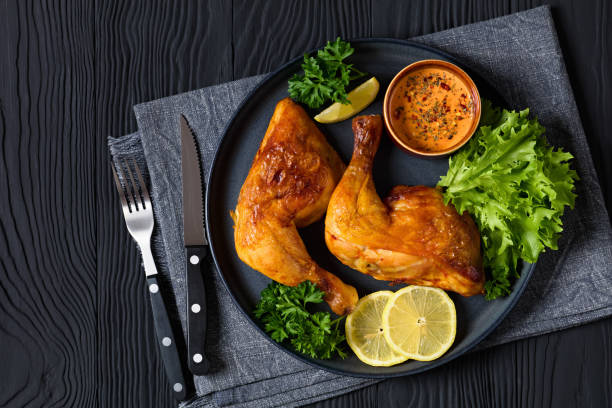 istock fried chicken legs with lettuce, lemon on plate 2172573278